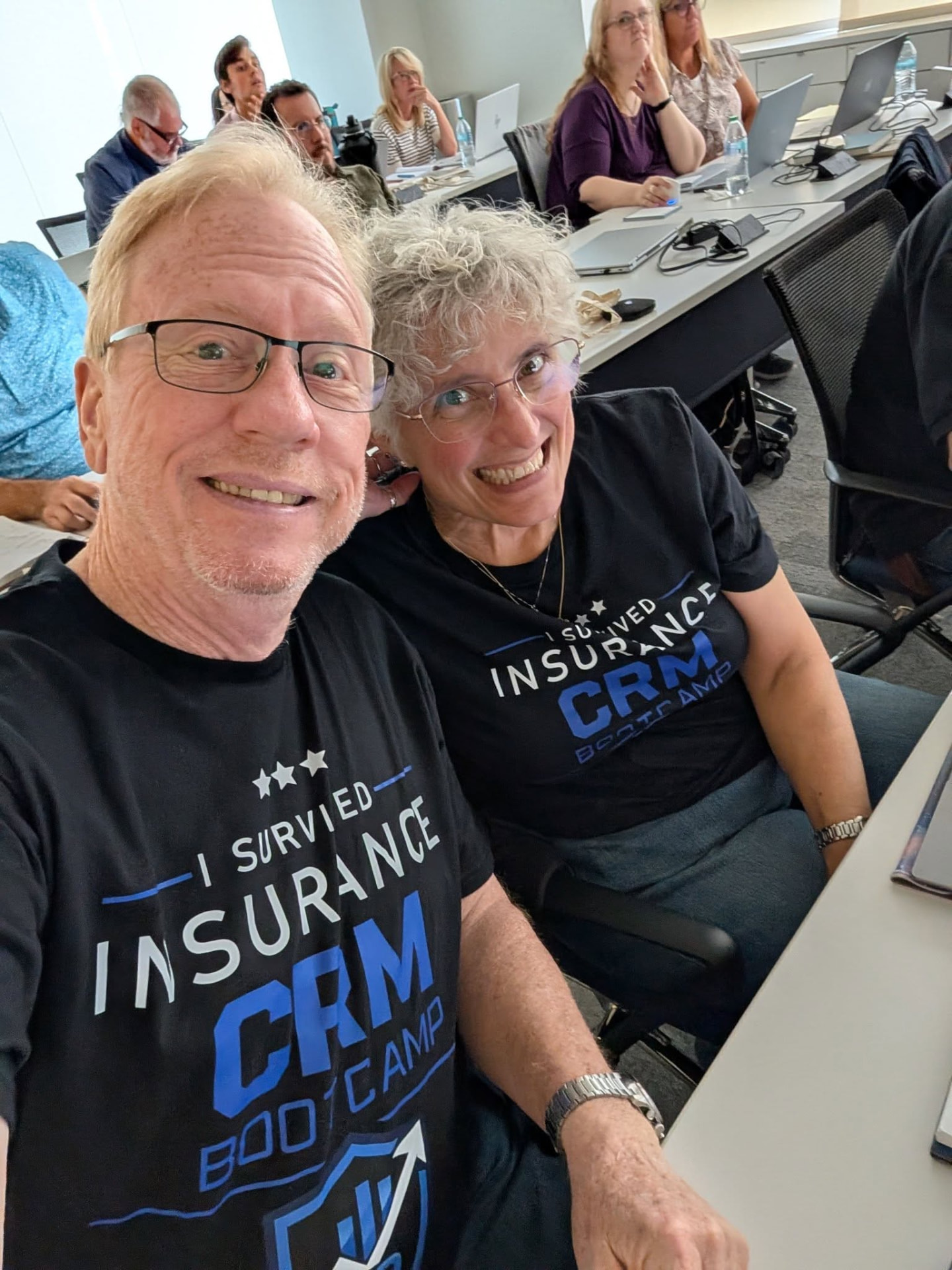 Two attendees smiling in their bootcamp shirts during class